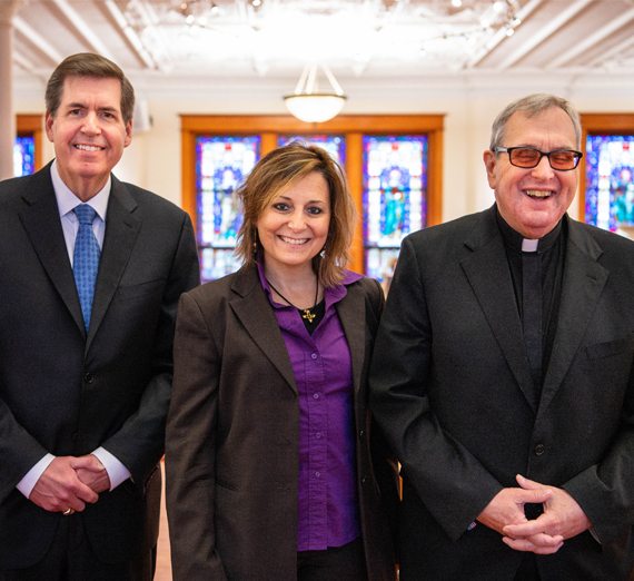 Hoeing and Rossi holding a Gonzaga flag at their wedding with guests.